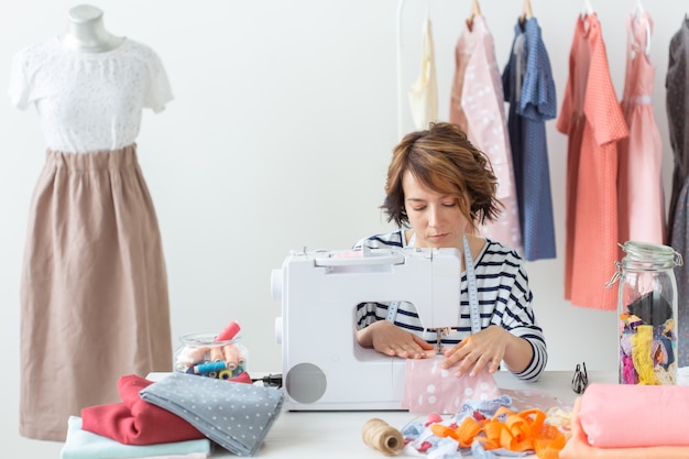 designer di abbigliamento, sarta, concetto di persone - sarta donna che lavora nel suo studio