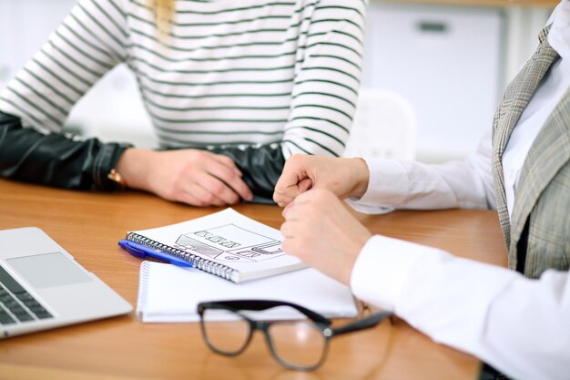 Designer di giovane donna d'affari che discute progetto di architettura con il cliente in ufficio. Concetto di business di avvio di successo.