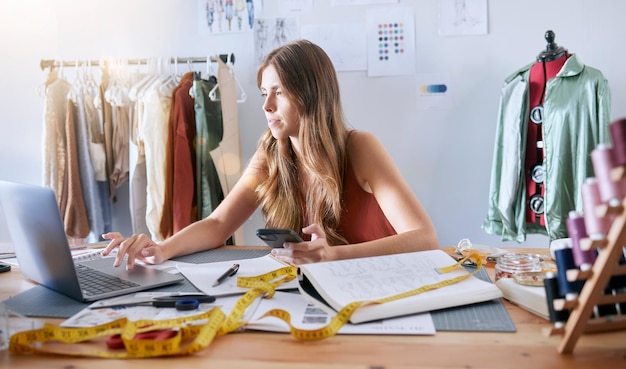 Designer di moda e donna per laptop che lavora su un design online con la tecnologia in un laboratorio Tecnologia creativa e proprietaria di una piccola impresa che pianifica una collezione di abbigliamento su un computer nel suo studio