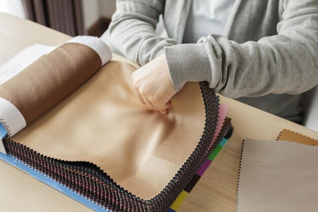 Designer femminile con campioni di colore del tessuto che sceglie il tessuto per le tende