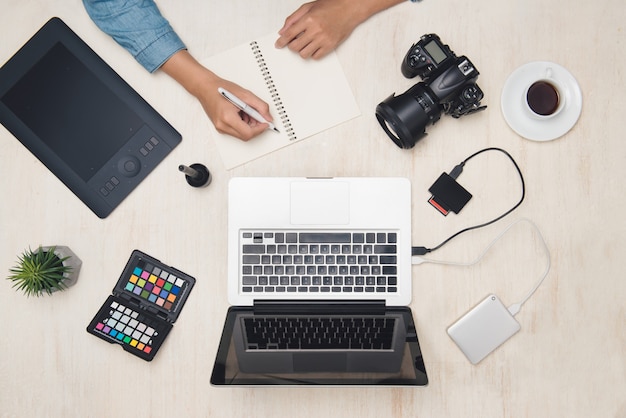 Designer fotografo maschio che lavora con tablet alla scrivania.