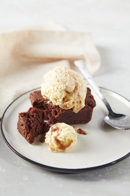 Dessert al cioccolato brownie con pallina di gelato cremoso alle noci su piatto con tovagliolo