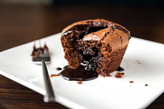 Dessert al cioccolato fondente su un piatto bianco e una forchetta