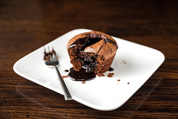 Dessert al cioccolato fondente su un piatto bianco e una forchetta