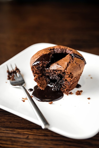 Dessert al cioccolato fondente su un piatto bianco e una forchetta