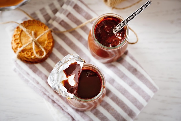 Dessert al cioccolato in piccoli vasetti di vetro su sfondo di legno