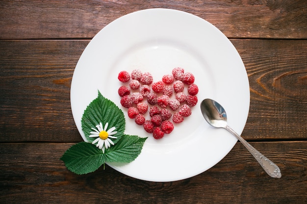 Dessert al lampone con zucchero in polvere sulla piastra. Segno d'amore