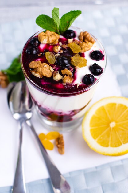 Dessert alla panna con frutti di bosco, marmellata di ribes nero e noci decorate con foglie di menta