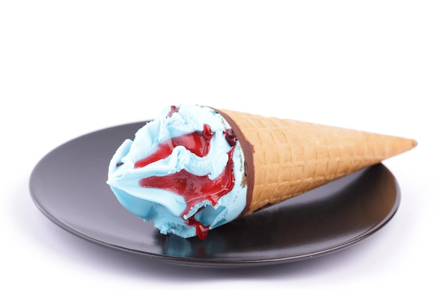 Dessert blu e rosso congelato Gelato in un cono di cialda su un primo piano piatto nero Cono gelato isolato su sfondo bianco