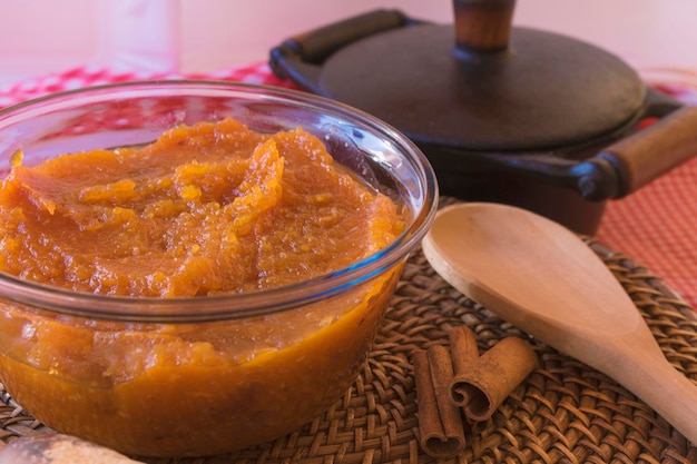 Dessert brasiliano dolce di zucca cocco e cannella in una ciotola e tavola di legno