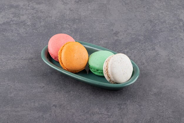 Dessert colorato macarons posto su un tavolo di pietra.