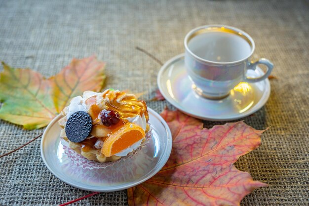 Dessert con arancia e marmellata sullo sfondo delle foglie autunnali Tartelletta dolce con crema e