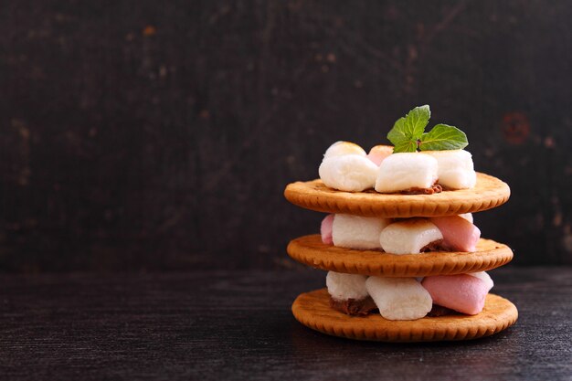 Dessert da biscotti, cioccolato e marshmallow su uno sfondo blu nella decorazione di Natale