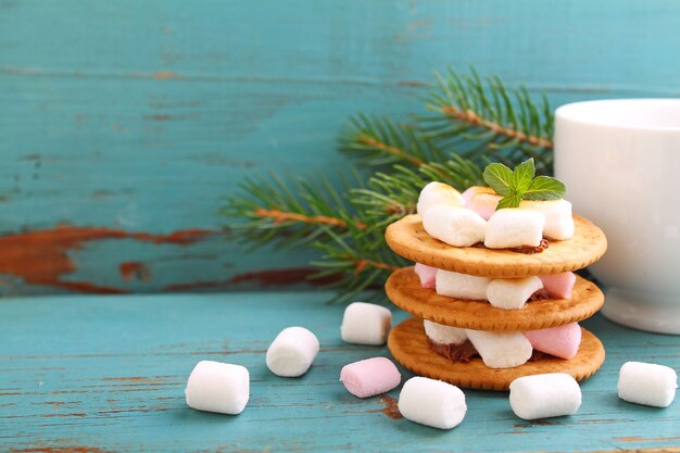 Dessert da biscotti, cioccolato e marshmallow su uno sfondo blu nella decorazione di Natale