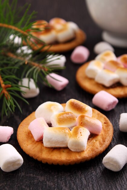 Dessert da biscotti con marshmallow su sfondo nero, decorazioni di Natale