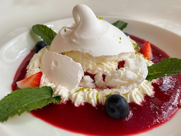 Dessert delizioso di Pavlova su un primo piano bianco del piatto