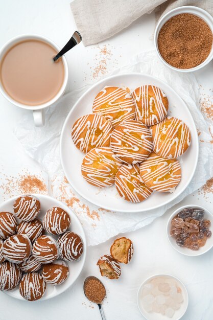 Dessert di due tipi di biscotti, zucchero di canna e una tazza di caffè su uno sfondo bianco.