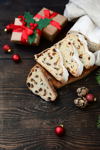 Dessert di natale del nuovo anno stollen affettato su una tabella di legno. Ricetta per cucina austriaca e tedesca. Natale in Europa