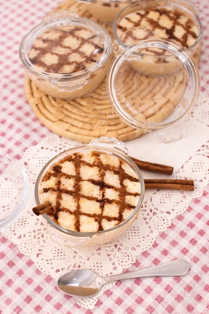 Dessert di riso dolce portoghese tradizionale su un tavolo con bastoncini di cannella.