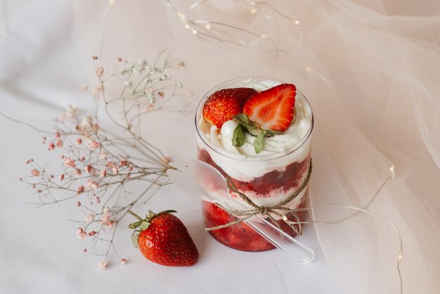 Dessert dolce in un primo piano di vetro e fragole