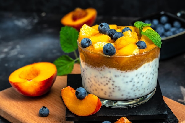 Dessert fatto in casa con semifreddo alla frutta yogurt con pesche mirtillo e chia posto per il testo