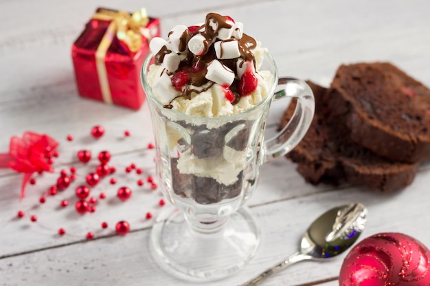 Dessert fatto in casa di Natale e decorazioni di Natale sulla tavola di legno bianca