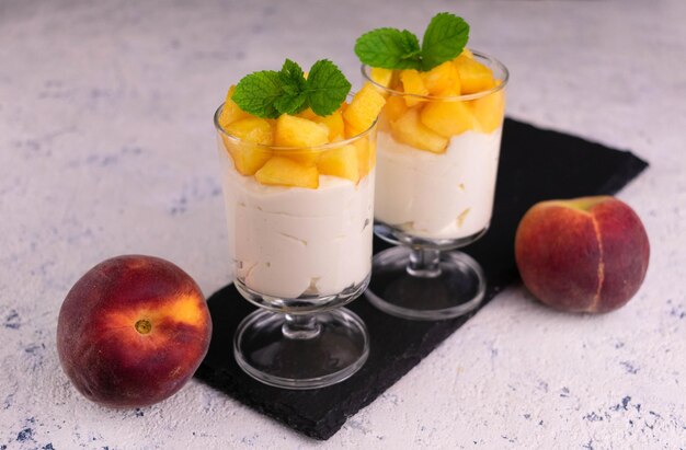 Dessert leggero con pesca e crema di formaggio su un piatto bianco