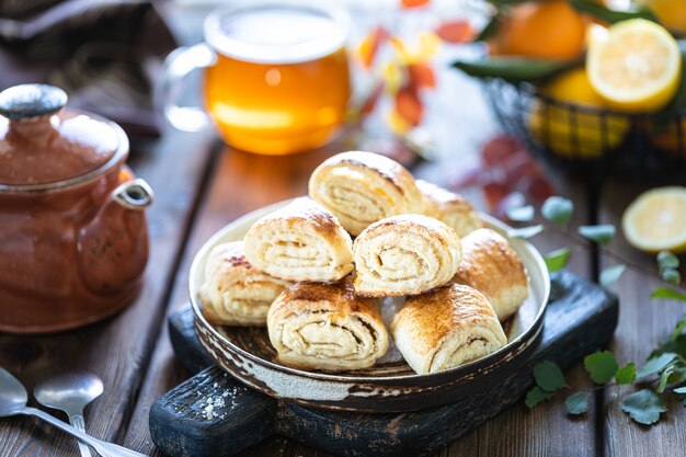 Dessert orientale gata con una tazza di tè e mandarini su una tavola di legno