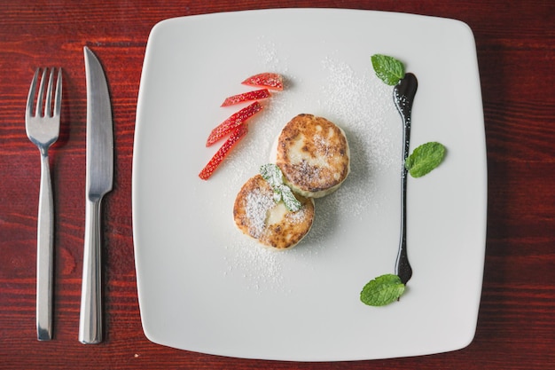 Dessert per la colazione - torta con ricotta, sous dolce verde e fragola, vista dall'alto