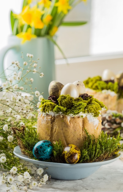 Dessert russo tradizionale della ricotta di Pasqua, Paskha ortodosso sulla tavola con i dolci di kulich, fiori, uova colorate.