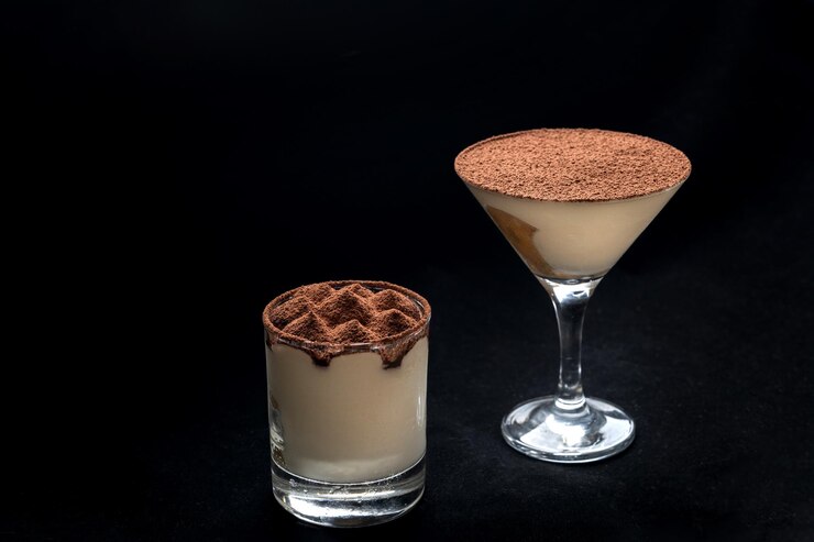 Dessert tiramisù con cannella cosparso di cacao in cima In una tazza di vetro nero sfondo isolato