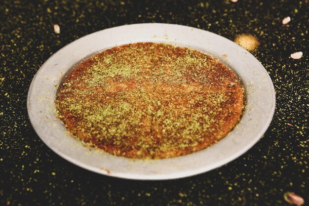 Dessert turco kunefe kunafa kadayif con polvere di pistacchio e formaggio caldo mangiato un dolce