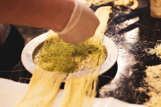 Dessert turco kunefe kunafa kadayif con polvere di pistacchio e formaggio caldo mangiato un dolce