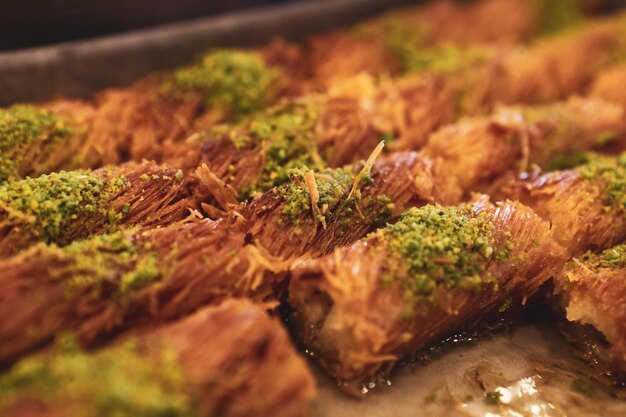 Dessert turco kunefe kunafa kadayif con polvere di pistacchio e formaggio caldo mangiato un dolce