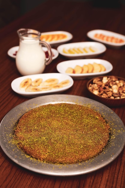 Dessert turco kunefe kunafa kadayif con polvere di pistacchio e formaggio caldo mangiato un dolce