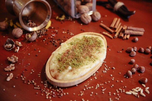 Dessert turco kunefe, kunafa, kadayif con polvere di pistacchio e formaggio caldo mangiato un dolce