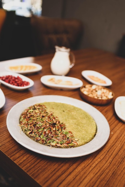 Dessert turco kunefe, kunafa, kadayif con polvere di pistacchio e formaggio caldo mangiato un dolce