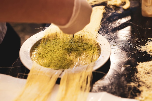 Dessert turco kunefe kunafa kadayif con polvere di pistacchio e formaggio caldo mangiato un dolce