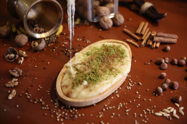 Dessert turco kunefe, kunafa, kadayif con polvere di pistacchio e formaggio caldo mangiato un dolce