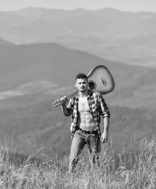 Destinazioni di vacanza Camminare da soli Uomo con la chitarra che cammina in cima alla montagna Il modo migliore per fuggire dalla città Ragazzo escursionista godersi la natura pura Esplorare la natura Bellezza della natura Aria fresca di montagna