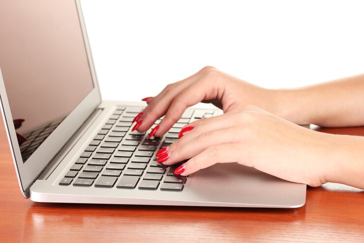 Photo detail of female hands using computer isolated on white