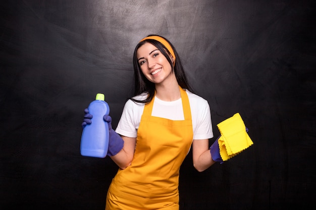 Detergente femminile deliziato con detersivo e panno