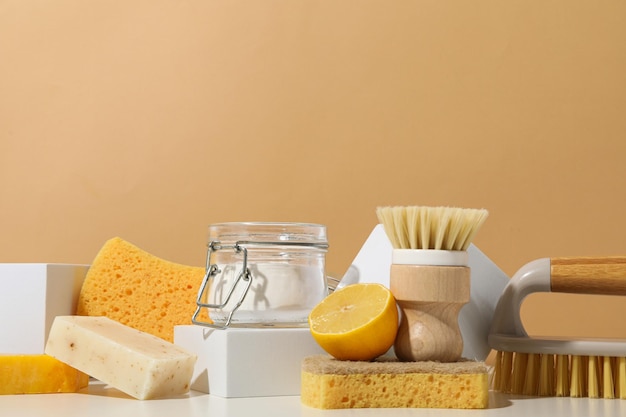 Detergenti naturali e strumenti di pulizia su sfondo beige per il testo