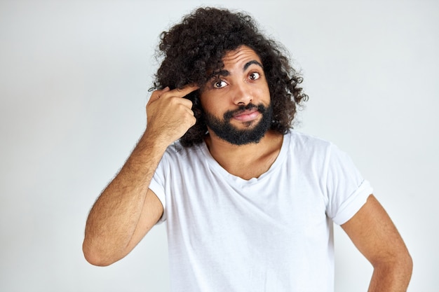 Determinato maschio arabo con la barba sta pensando e sembra preoccupato