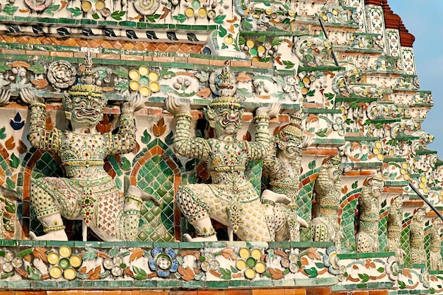 Dettagli architettonici di Wat Arun con file di mitiche sculture di demoni Yaksha a Bangkok in Thailandia