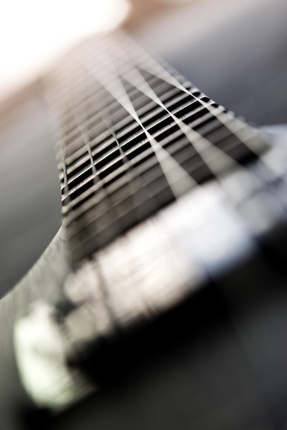 Dettagli del corpo e della tastiera di una chitarra elettrica. Illuminazione scenica, musica leggera.