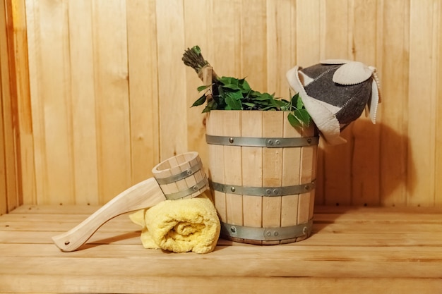 Dettagli interni sauna finlandese bagno di vapore con accessori sauna tradizionale bacino scopa di betulla scoop cappello in feltro asciugamano. Vecchio concetto russo tradizionale della stazione termale dello stabilimento balneare. Rilassa il concetto di bagno del villaggio di campagna