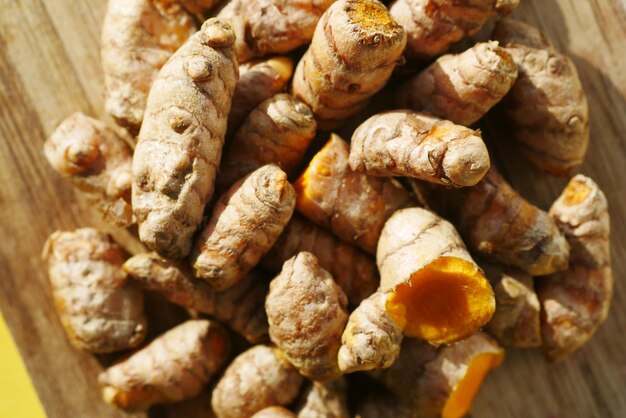 Dettaglio colpo di radice di curcuma in una ciotola sul tavolo