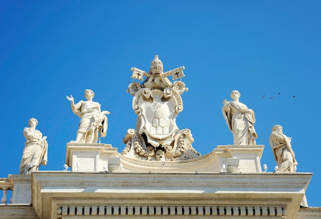 Dettaglio dal colonnato barocco di San Pietro con bellissime statue di santi e stemma di Papa Alessandro VII Città del Vaticano Roma Italia