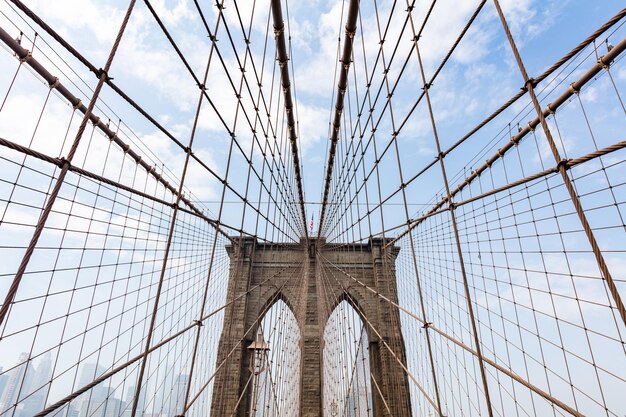 Dettaglio del ponte di Brooklyn su sfondo blu cielo nuvoloso New York City Manhattan